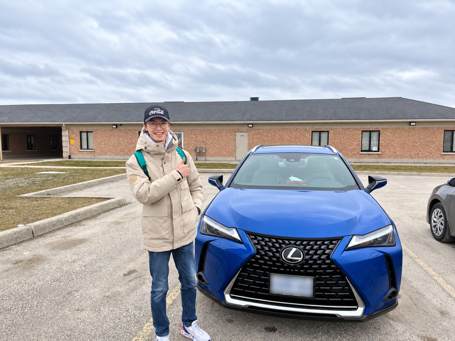 KM Driving 真实教学案例人物与蓝色教学车辆合影，车牌已做隐私处理